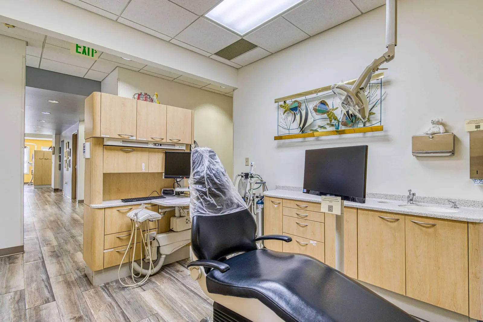 A treatment room with the chair beside a window looking onto trees