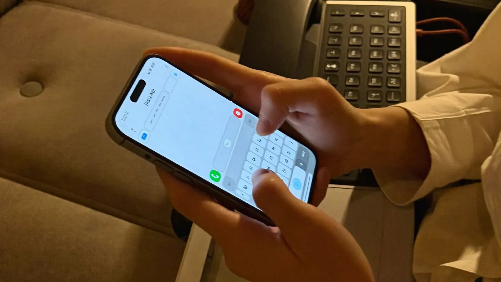 Hands typing a message on a phone in the evening