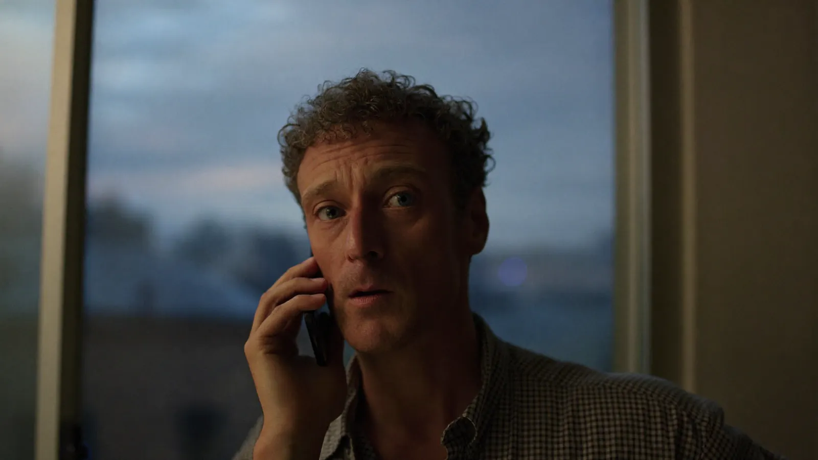 A man on the phone at dusk, calling a practice after hours
